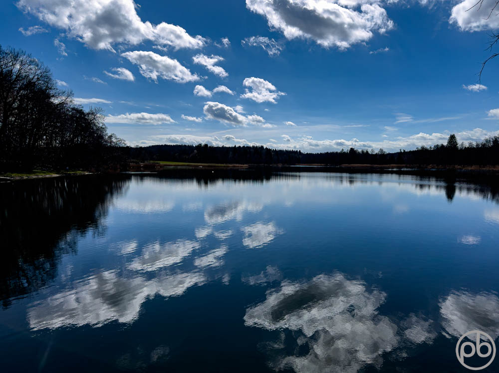 Wolkenspiegelung auf ruhiger Wasseroberfläche